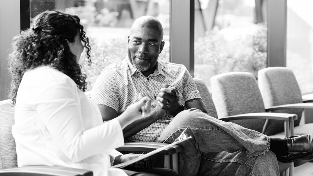 An older male speaking with a healthcare professional about Inspire for sleep apnea.