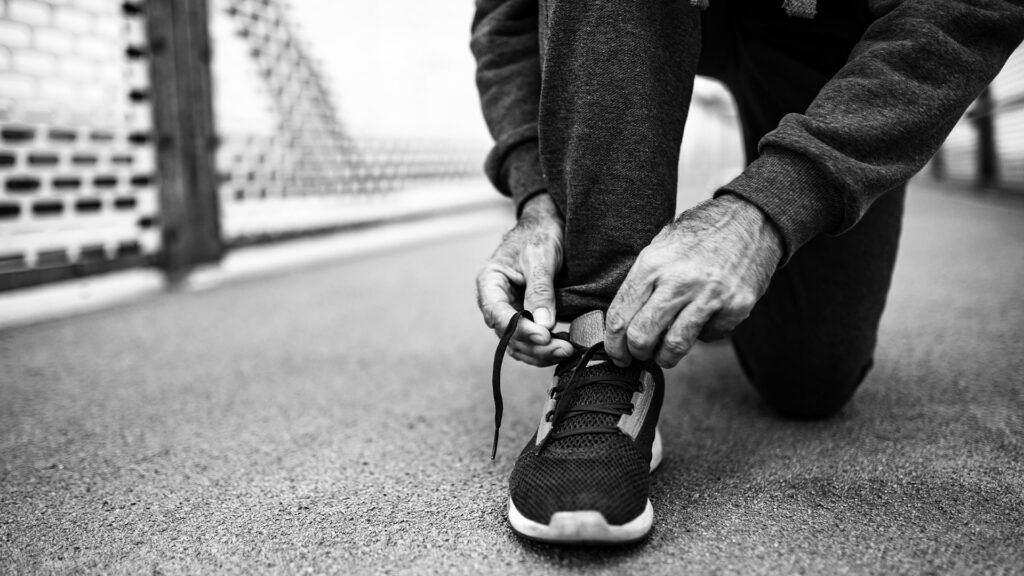 A person lacing up one shoe 1