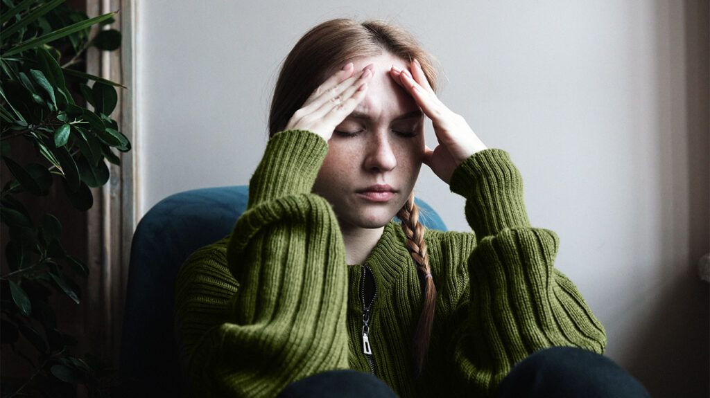 A woman experiences a headache in her temples. 