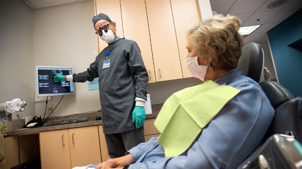 A senior patient discussing dental treatment with an orthodontist. -1