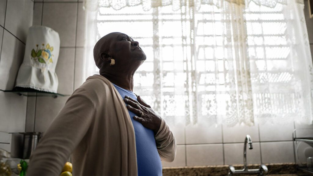 older Black woman pressing a hand to her chest