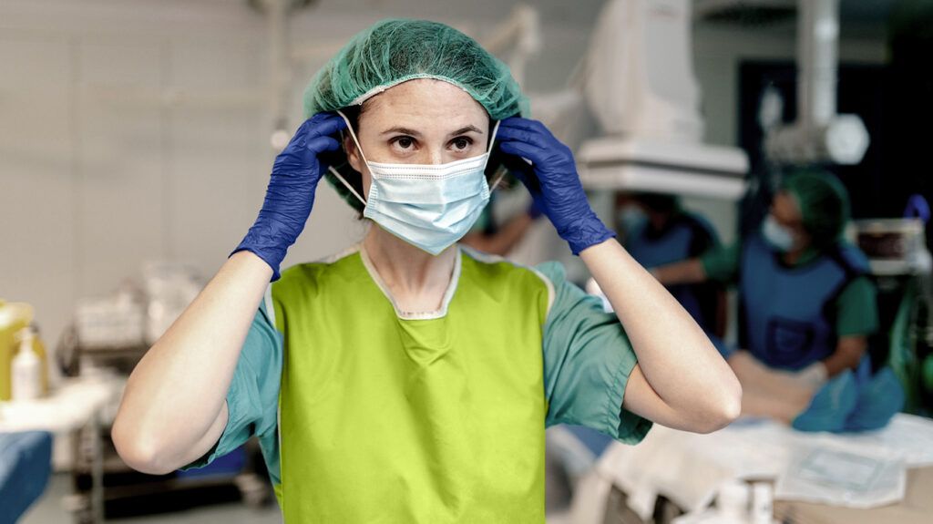 Surgeon adjusting a surgical mask 1