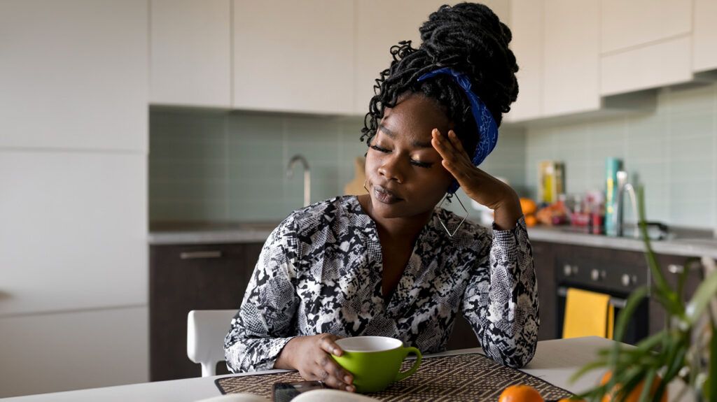 Female sitting at a table with a headache