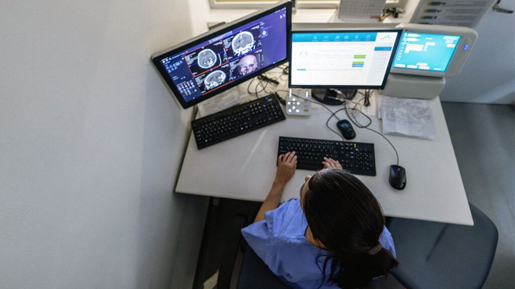 Healthcare professional reviewing brain scans on a screen