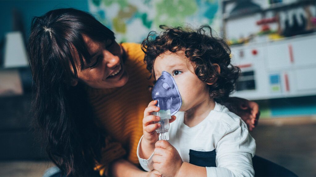 A mother helping her child with an inhalation mask