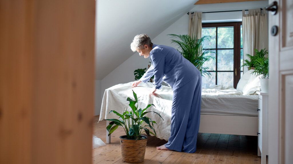 Senior woman making the bed