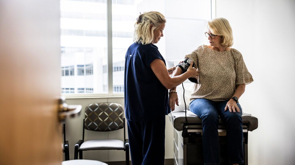 A nurse taking a person's blood pressure.