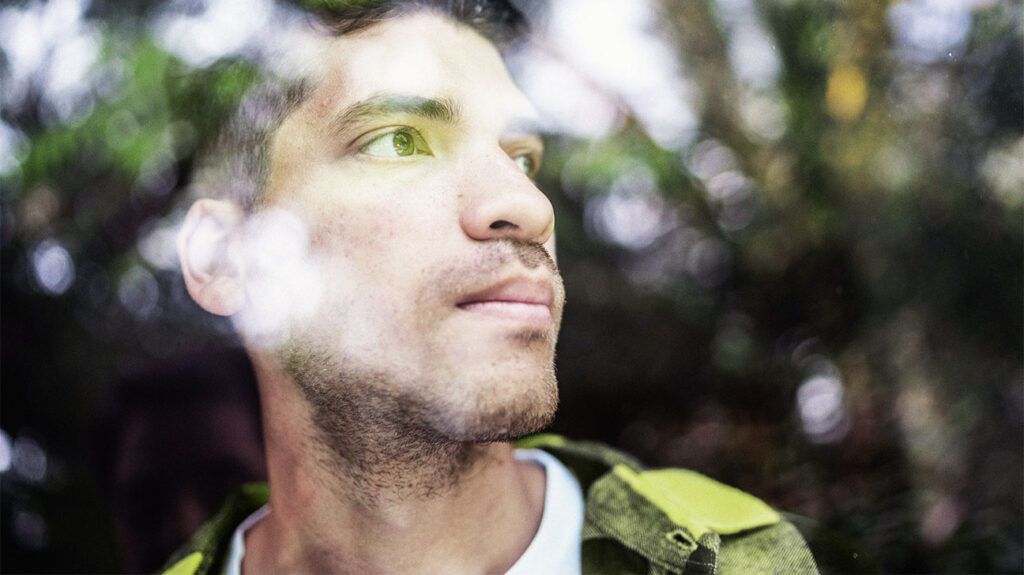 A man looking out of a window in thought.