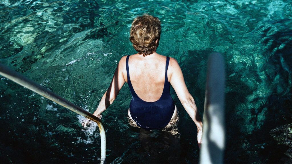 An older woman entering a pool-1