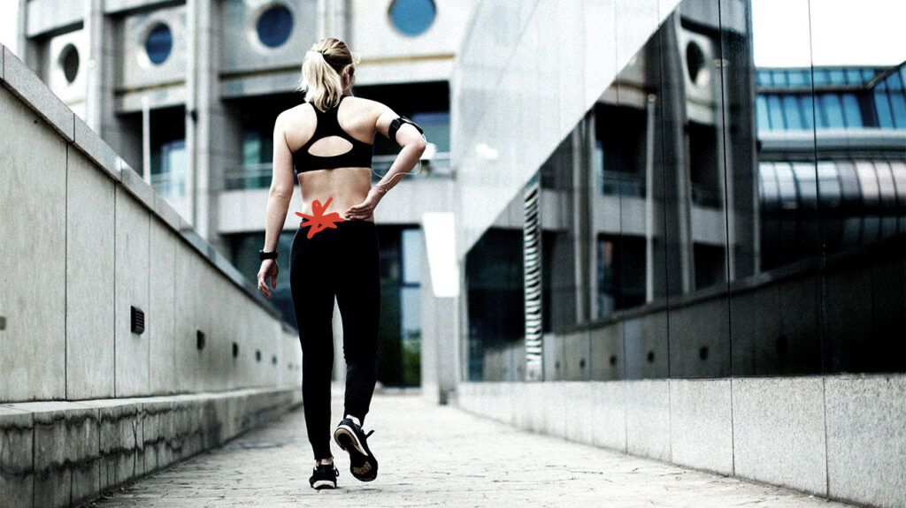 한 여성 달리기 선수가 허리 아랫부분을 움켜쥐고 있다.<BR>