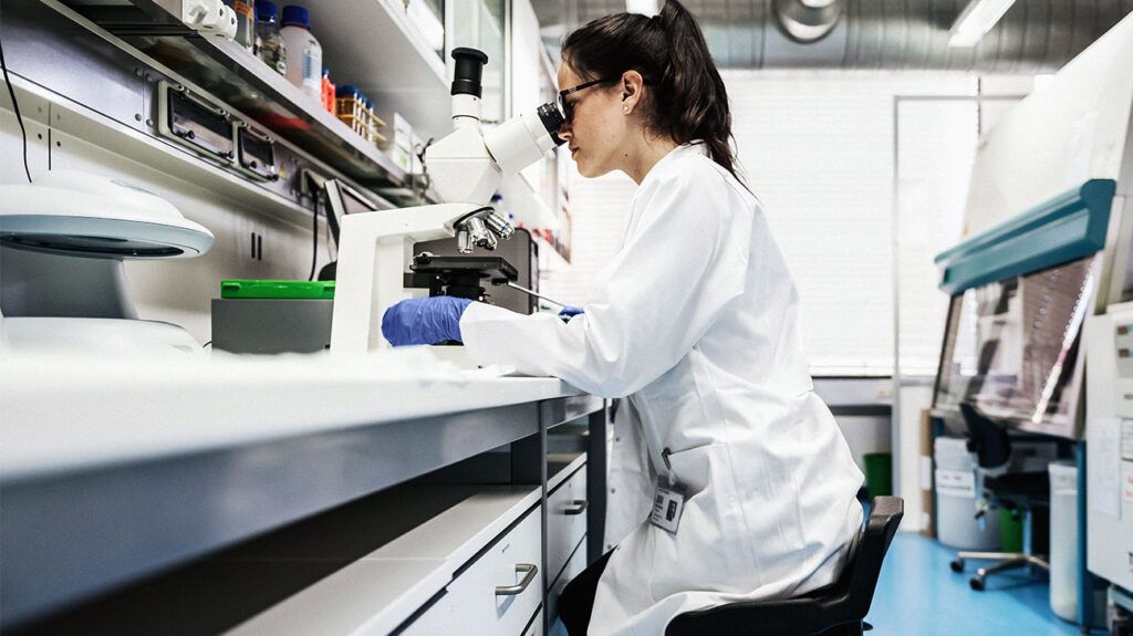 Female pathologist looking through a microscope-1