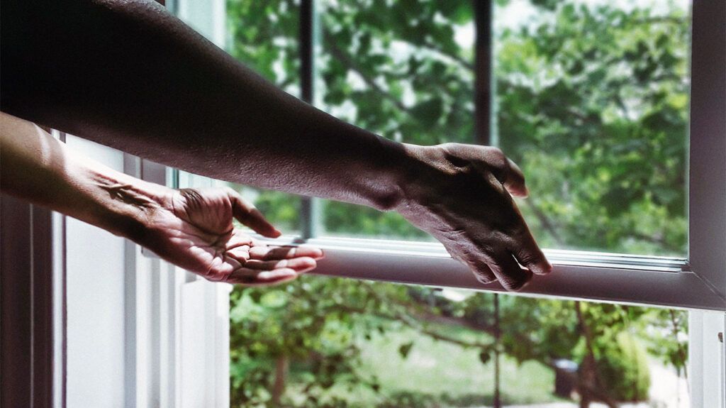 A persons hands opening a window from indoors 1