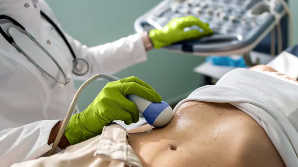 Healthcare professional using ultrasound wand over a person's abdomen