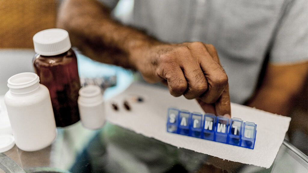 person adding pills to pill organiser