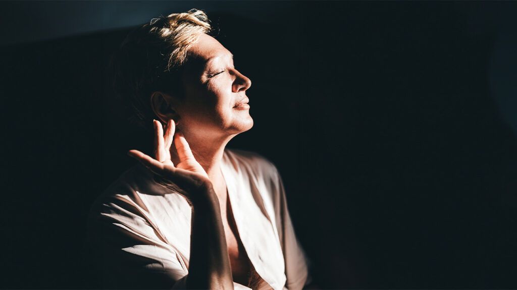 Elderly Caucasian woman in profile against dark background