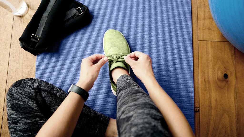 Woman tying shoelaces before training