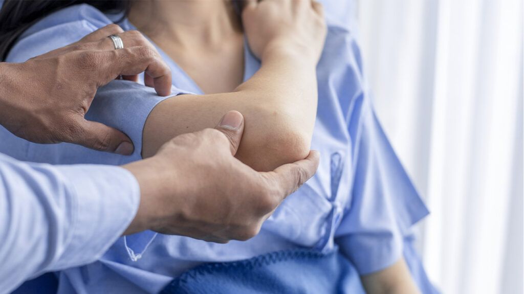 A doctor examining an elbow for osteochondritis dissecans.
