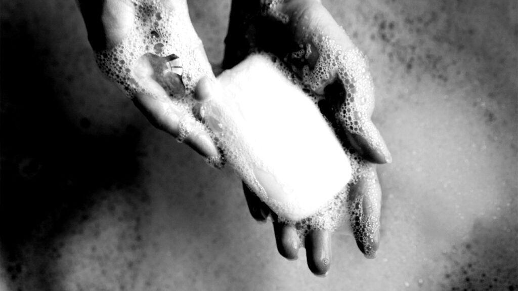 A person holding a bar of soap.