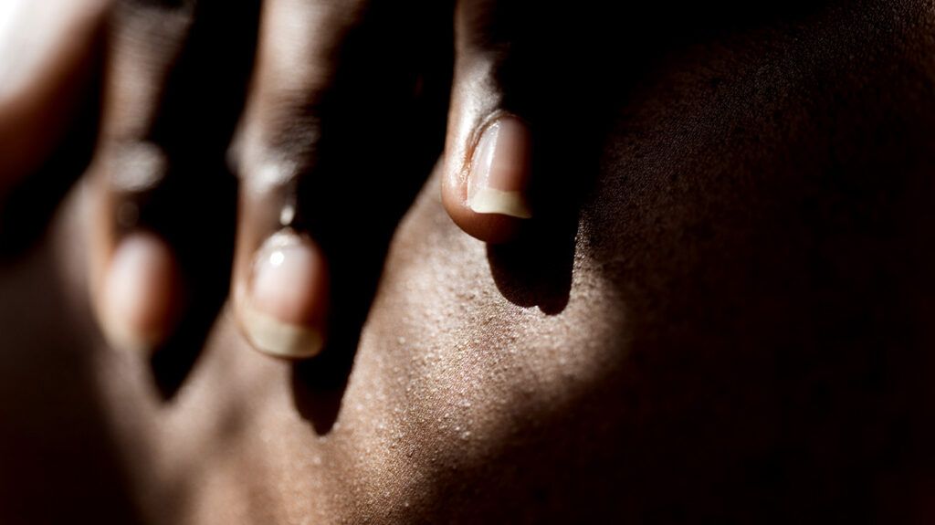 그림자가 드리워진 피부에 닿는 손가락