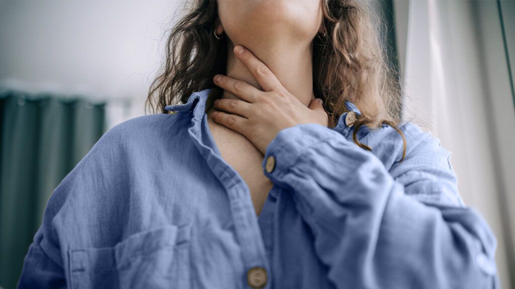 a woman holding her throat