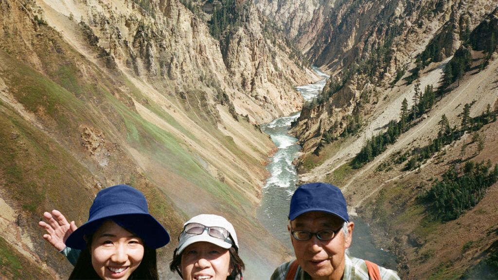 A selfie of a family wearing hats with a canyon in the background.-1
