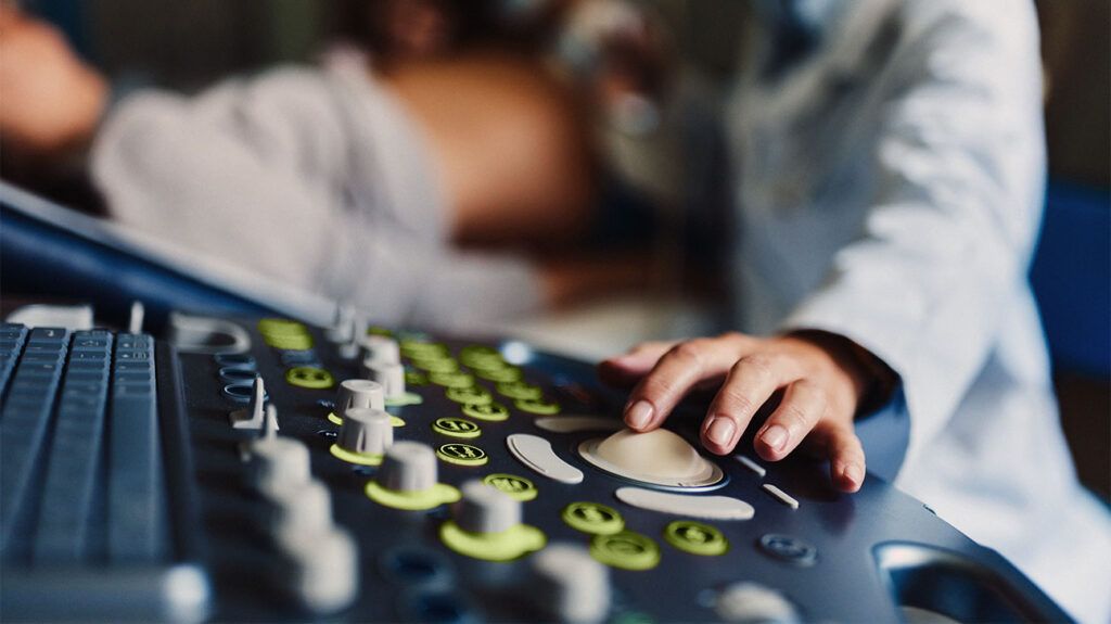 A nurse operating an ultrasound machine to view a molar pregnancy. -2