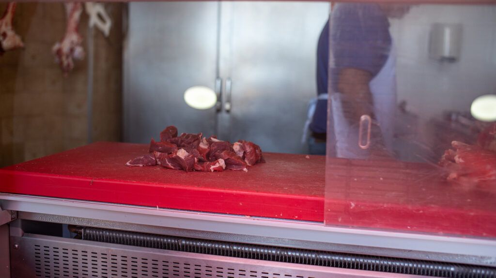 Pieces of chopped red meat on a counter at a butcher's