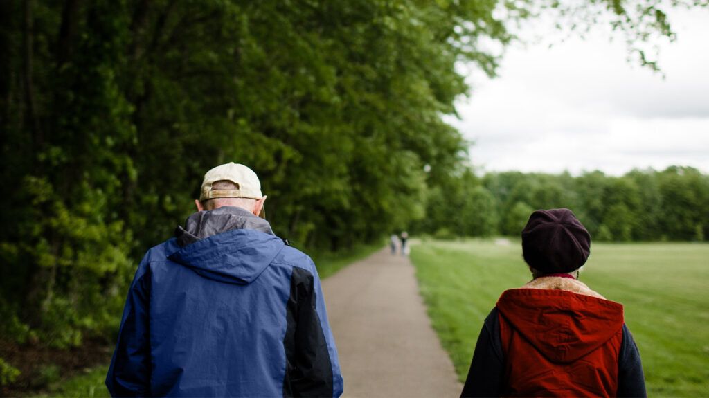 Older couple walking through a park together