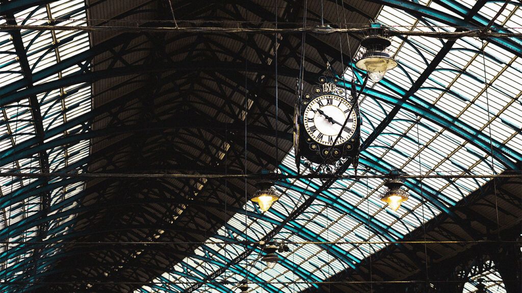 A clock hanging below glass panels 1