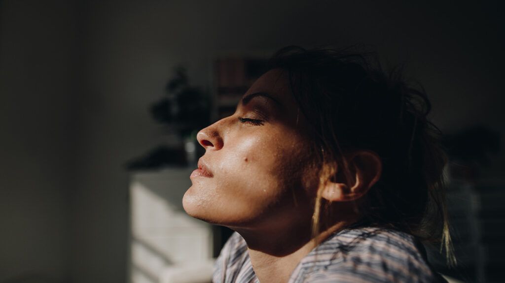 A woman sitting with her eyes closed.
