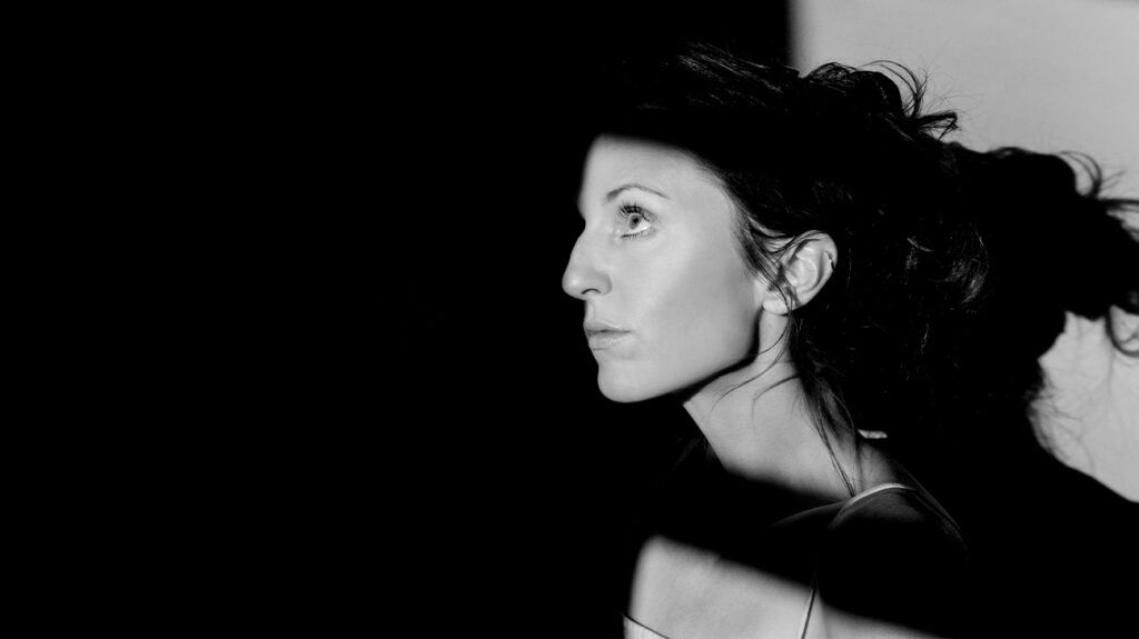 A person with light shining on their face 1