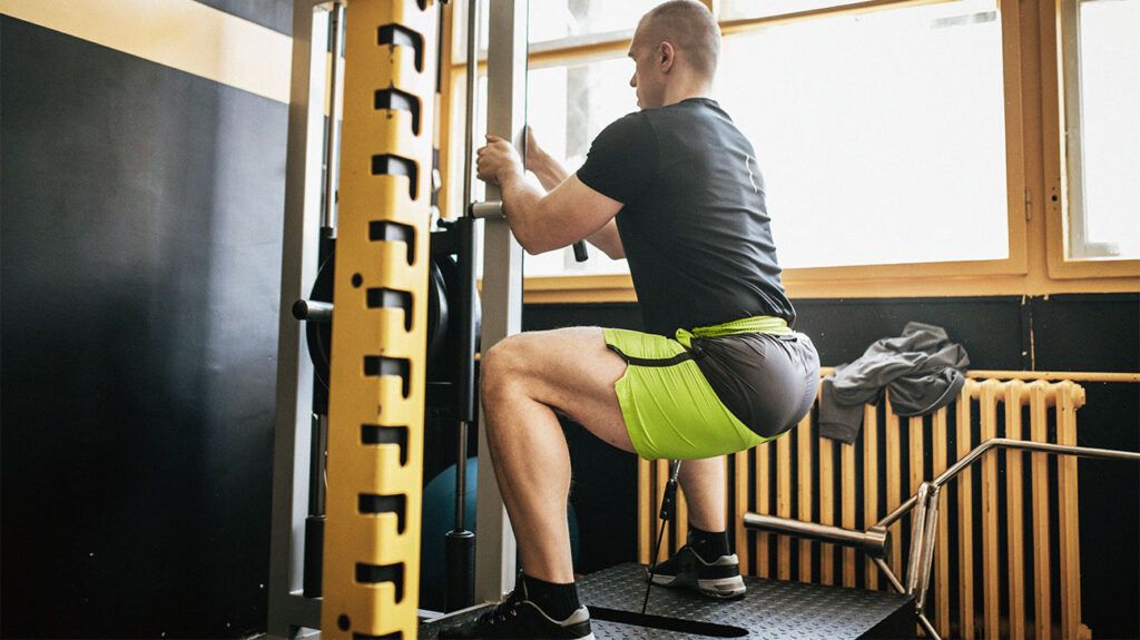 man doing squats in a gym-2