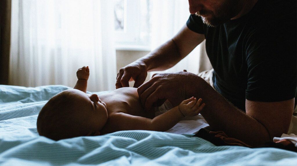 Parent changing a baby's diaper