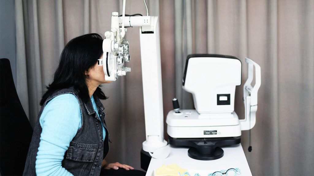 A person looking through optometry equipment for an eye examination.-2