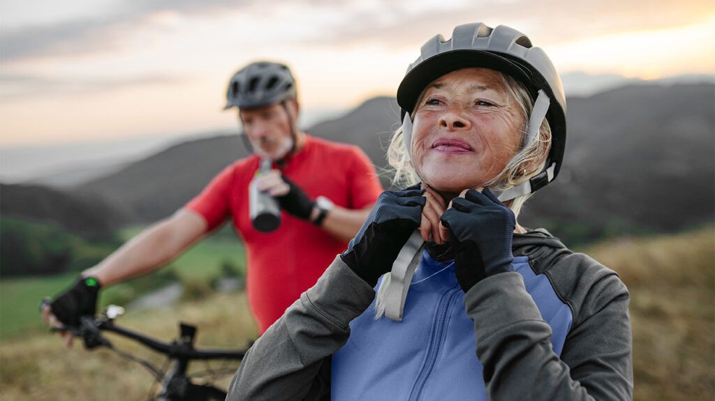 Couple cycling surrounded by hills