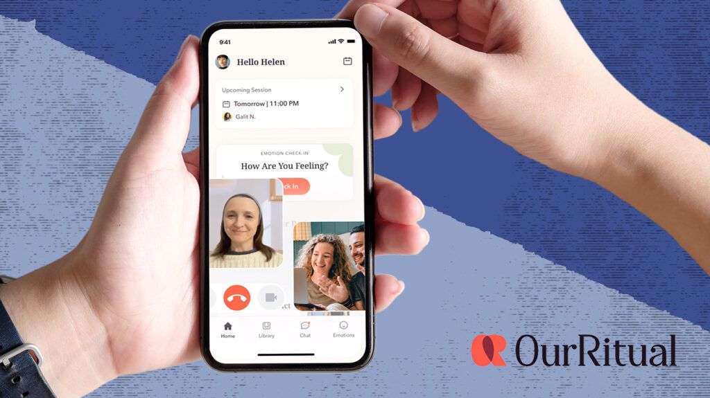 Our Ritual app screenshot on a smartphone being held by a person&rsquo;s hand, in the foreground we can see the backs of two peoples head as they look at the phone for couples counseling. Photo is isolated on dark blue background.