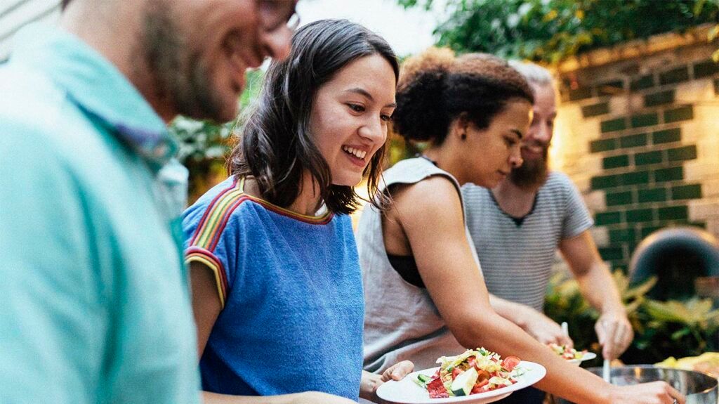 People filling up their plate at a bbq