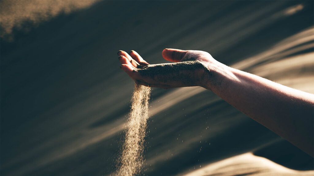 Sand slipping through someone's fingers