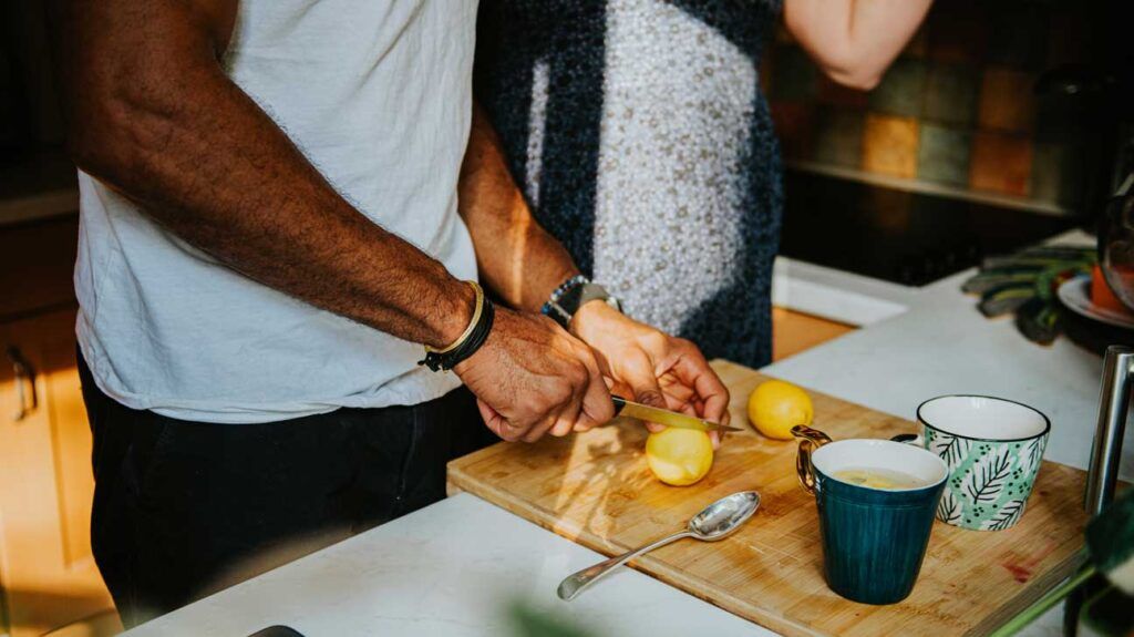 A person slicing lemons to make hot lemon water before bed.