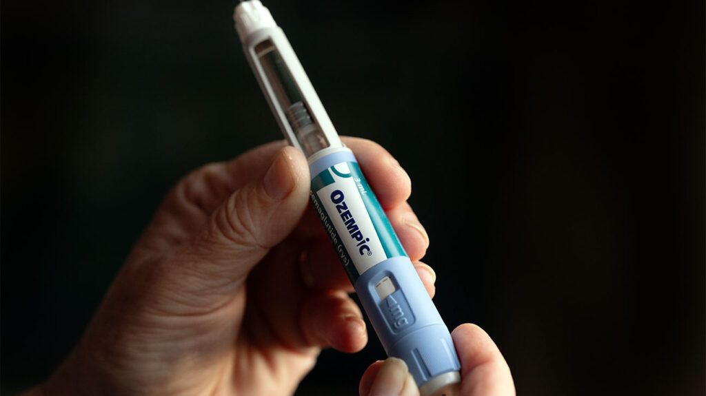 A person holding an Ozempic pen, the active ingredient of which is semaglutide