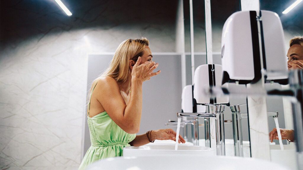 Woman fixing her make-up in a public bathroom