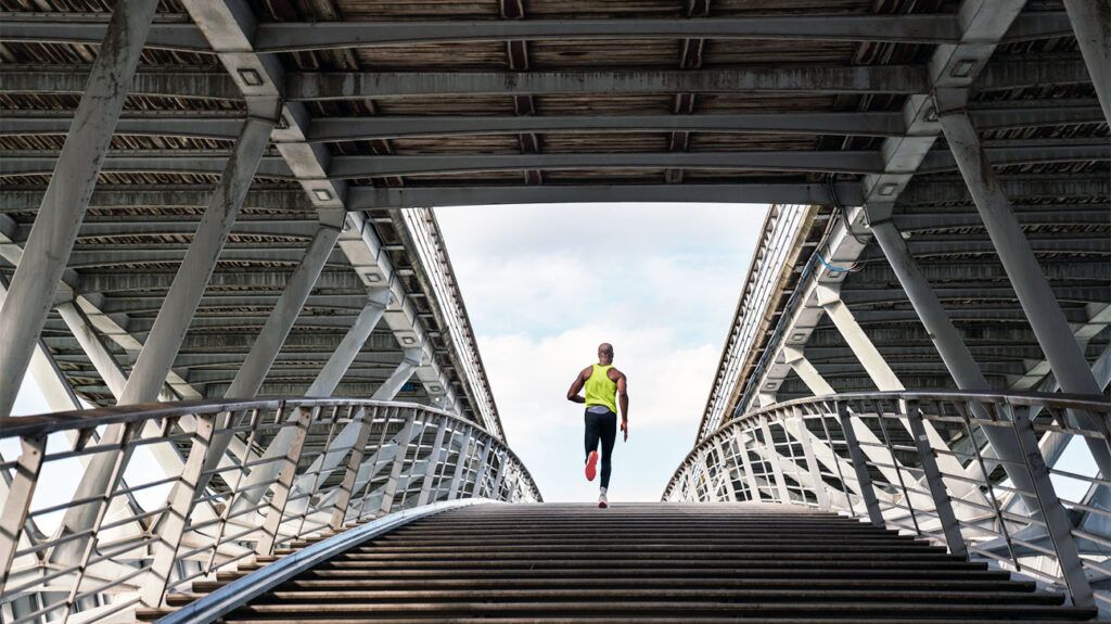 person jogging across bridge