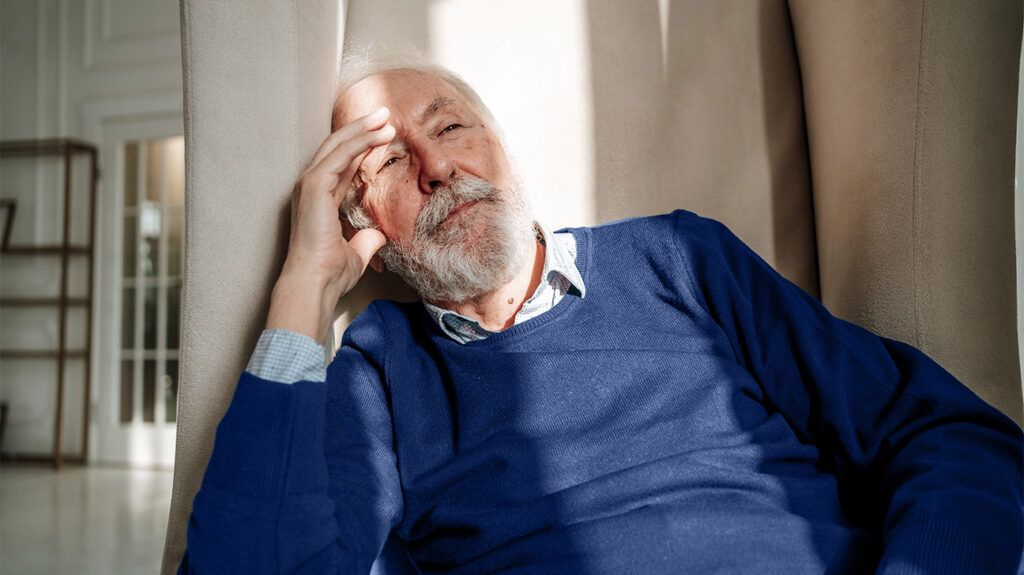 older white man slumping against wall