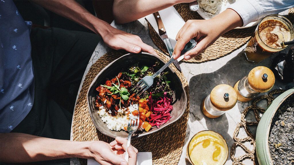 건강식 한 그릇. 신선한 채소, 소고기, 밥이 큰 접시에 담겨 있다.<BR> 화창한 날, 카페에서 식사를 하는 모습.