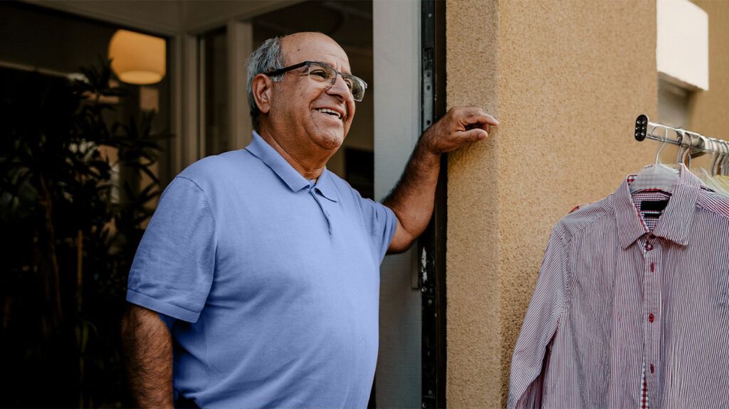 smiling older man standing in doorway