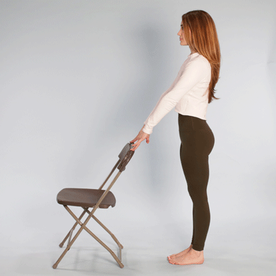 Standing knee raise with person holding chair for support
