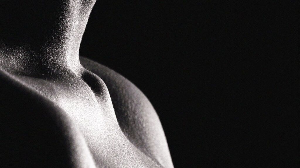 Black and white image, a person's collar bones, stark light