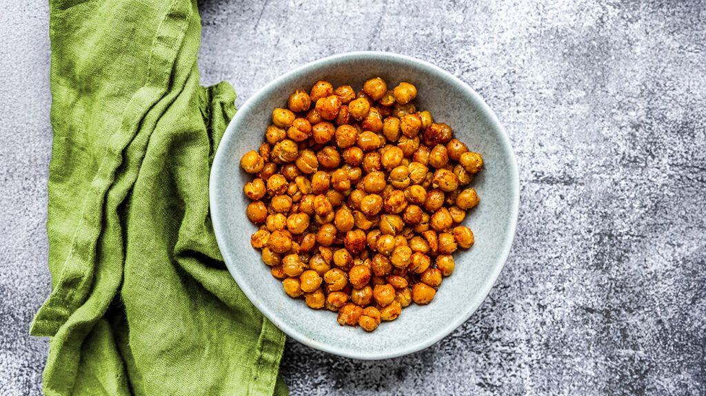 A bowl of chickpeas from above, a tea towel on the side