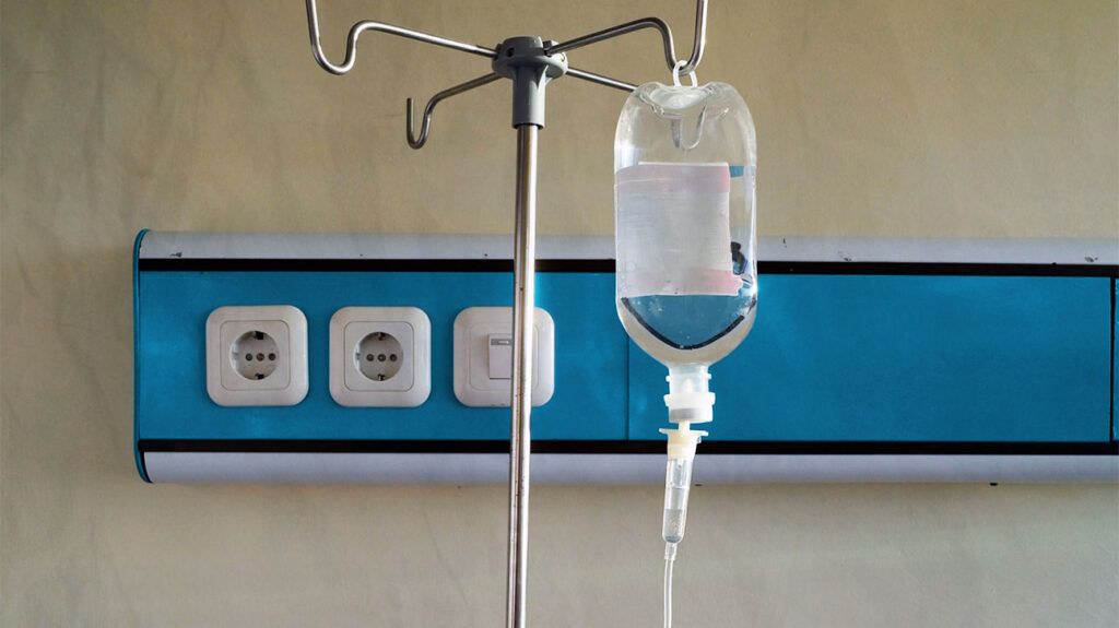 A bag of fluids hanging for intravenous administration in a hospital.-2