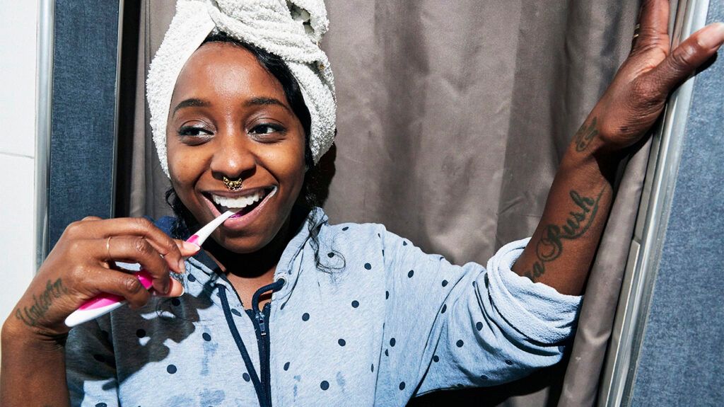 a woman brushing her teeth and smiling-1